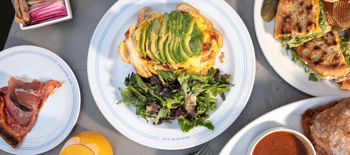 Avocado toast on thick-cut bread with a side of greens